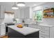 Bright kitchen with white cabinets, marble countertops, stainless steel appliances, and a dark island at 1013 New Chester Ct, Apex, NC 27502