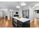 Kitchen featuring white cabinets, stainless steel appliances, a black island, and hardwood flooring at 1013 New Chester Ct, Apex, NC 27502