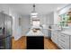 Modern kitchen with white cabinets, a black island, stainless steel appliances, and hardwood floors at 1013 New Chester Ct, Apex, NC 27502