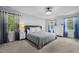 Spacious bedroom featuring large windows, neutral carpet, and a decorative ceiling fan at 1013 New Chester Ct, Apex, NC 27502