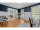 Well-lit home office with chair, light blue walls with white trim, and door to living area at 1013 New Chester Ct, Apex, NC 27502