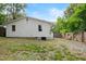 Backyard view of home with white siding, green grass, wooden fencing, and trees at 1014 E Club Blvd, Durham, NC 27704