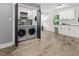 Functional laundry area, washer and dryer, next to white cabinets with wood flooring and natural light at 1014 E Club Blvd, Durham, NC 27704