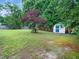 Lush backyard features mature trees, a storage shed, and ample space for gardening and outdoor activities at 102 Heritage Ridge Ct, Knightdale, NC 27545