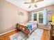 Charming bedroom with a colorful quilt, hardwood floors, and bright decor creating a cozy and cheerful space at 102 Heritage Ridge Ct, Knightdale, NC 27545