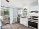 Bright kitchen features white cabinets, stainless steel appliances, and a sliding glass door to the outdoors at 102 Heritage Ridge Ct, Knightdale, NC 27545