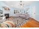 Cozy living room with fireplace, ceiling fan, and comfortable gray sectional sofa on a floral rug at 102 Heritage Ridge Ct, Knightdale, NC 27545