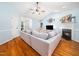 Spacious living room featuring a fireplace, ceiling fan, plush sectional sofa, hardwood floors, and a TV at 102 Heritage Ridge Ct, Knightdale, NC 27545