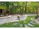 Landscaped backyard featuring stone steps and walls, enhancing the outdoor space with natural beauty and functionality at 1025 Kingsway Dr, Apex, NC 27502
