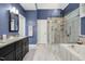 The large bathroom has a double granite vanity, a glass enclosed shower and a soaking tub at 1025 Kingsway Dr, Apex, NC 27502