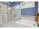 The bathroom boasts a glass walk-in shower and soaking tub, with a view from the window at 1025 Kingsway Dr, Apex, NC 27502