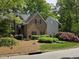Brick home with well-maintained lawn, surrounded by trees and colorful landscaping at 1025 Kingsway Dr, Apex, NC 27502