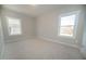 An empty bedroom with neutral walls, carpet flooring, and natural light from two windows at 105 Ambergate Ct, Rocky Mount, NC 27804