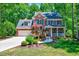 Traditional brick home featuring a two-car garage, lush landscaping, and classic blue shutters at 105 Wittenham Dr, Cary, NC 27519
