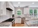Bright kitchen featuring white cabinets, stainless appliances, and stone countertops near a large window at 105 Wittenham Dr, Cary, NC 27519