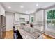 Bright kitchen featuring an island with seating, stainless steel appliances, and white cabinetry at 105 Wittenham Dr, Cary, NC 27519