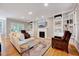 Bright living room featuring hardwood floors, a fireplace, and built-in bookshelves at 105 Wittenham Dr, Cary, NC 27519