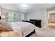 Comfortable main bedroom with two large windows with shutters, dresser, and an attached bathroom at 105 Wittenham Dr, Cary, NC 27519