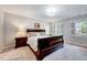 Spacious main bedroom featuring carpet, windows with shutters, a bed, and bedside tables at 105 Wittenham Dr, Cary, NC 27519