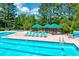 Relaxing pool area with lounge chairs and shaded seating, surrounded by lush greenery at 105 Wittenham Dr, Cary, NC 27519
