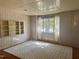 Bright living room with built-in shelving, large windows, and a stylish geometric rug on hardwood floors at 109 Stephens St, Chapel Hill, NC 27516