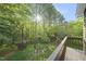 Overlooking the lush backyard with mature trees and privacy fencing from a second story deck at 13 Crosswinds Estates Dr, Pittsboro, NC 27312