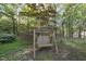 A tranquil backyard featuring a swing set amongst mature trees and greenery at 13 Crosswinds Estates Dr, Pittsboro, NC 27312