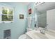 Cozy bathroom features a white sink, vanity, and glass-enclosed shower, complemented by a window for natural light at 13 Crosswinds Estates Dr, Pittsboro, NC 27312