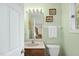 Half bath features a wood vanity, decorative mirror, and natural light at 13 Crosswinds Estates Dr, Pittsboro, NC 27312