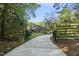 Gated driveway leads to a two-story home surrounded by lush trees at 13 Crosswinds Estates Dr, Pittsboro, NC 27312