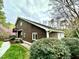Side view of a home showcasing the wood siding, green landscaping, and a glimpse of the blooming trees at 13 Crosswinds Estates Dr, Pittsboro, NC 27312