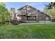 Two-story home featuring wood facade, balcony, and a stone chimney, with a manicured lawn at 13 Crosswinds Estates Dr, Pittsboro, NC 27312