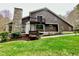 Two-story home displaying a stone chimney, balcony, and well-manicured lawn at 13 Crosswinds Estates Dr, Pittsboro, NC 27312