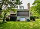 Charming home exterior with a stone chimney, deck, green lawn, and mature trees at 13 Crosswinds Estates Dr, Pittsboro, NC 27312