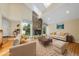 Bright living room with a stone fireplace, skylights, hardwood floors, and comfortable seating at 13 Crosswinds Estates Dr, Pittsboro, NC 27312