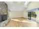 Light-filled living room showcases a stone fireplace, hardwood floors, and a sliding door to the deck at 13 Crosswinds Estates Dr, Pittsboro, NC 27312
