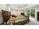 Well-lit main bedroom with a large bed, balcony, and access to the bathroom at 13 Crosswinds Estates Dr, Pittsboro, NC 27312