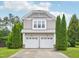 Two-story home features a two-car garage and manicured evergreens in the front yard at 13 Pegram Ct, Durham, NC 27703
