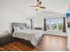 Spacious main bedroom features modern ceiling fan, laminate flooring, and a view of the outdoors at 13 Pegram Ct, Durham, NC 27703