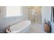 Bright bathroom featuring a luxurious bathtub, marble floors, and a towel rack at 134 Cotten Dr, Morrisville, NC 27560