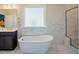 Bright bathroom with a freestanding tub, marble tile, walk-in shower, and a dark vanity at 134 Cotten Dr, Morrisville, NC 27560