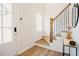 Bright entryway showcasing hardwood floors, a staircase with metal railings, and a stylish side table at 134 Cotten Dr, Morrisville, NC 27560