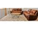 A bright and open living room featuring leather couches and a decorative rug at 134 Cotten Dr, Morrisville, NC 27560