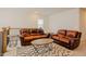 A bright and open living room featuring leather couches and a decorative rug at 134 Cotten Dr, Morrisville, NC 27560
