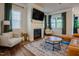 Cozy living room featuring a fireplace, comfortable seating, and natural light from the windows at 134 Cotten Dr, Morrisville, NC 27560