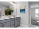 Bathroom features a gray double vanity, neutral walls, and a view into an adjacent carpeted bedroom at 1412 Main St, Lillington, NC 27546