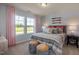 Comfortable bedroom featuring neutral decor with a bed dressed in gray stripes and views of the green outdoors at 1412 Main St, Lillington, NC 27546