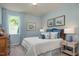 Comfortable bedroom featuring a cozy bed with blue accents, complementary wall art, and natural light at 1412 Main St, Lillington, NC 27546
