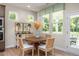 Bright and airy dining area with a round table, wicker chairs, and large windows overlooking the backyard at 1412 Main St, Lillington, NC 27546