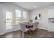 Bright dining area featuring a modern table and chairs, hardwood flooring, and a sliding glass door at 1412 Main St, Lillington, NC 27546